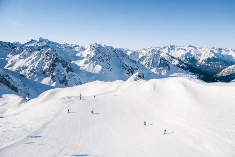 Des skieurs parcourent les pistes du Grand Tourmalet face aux sommets enneigés.