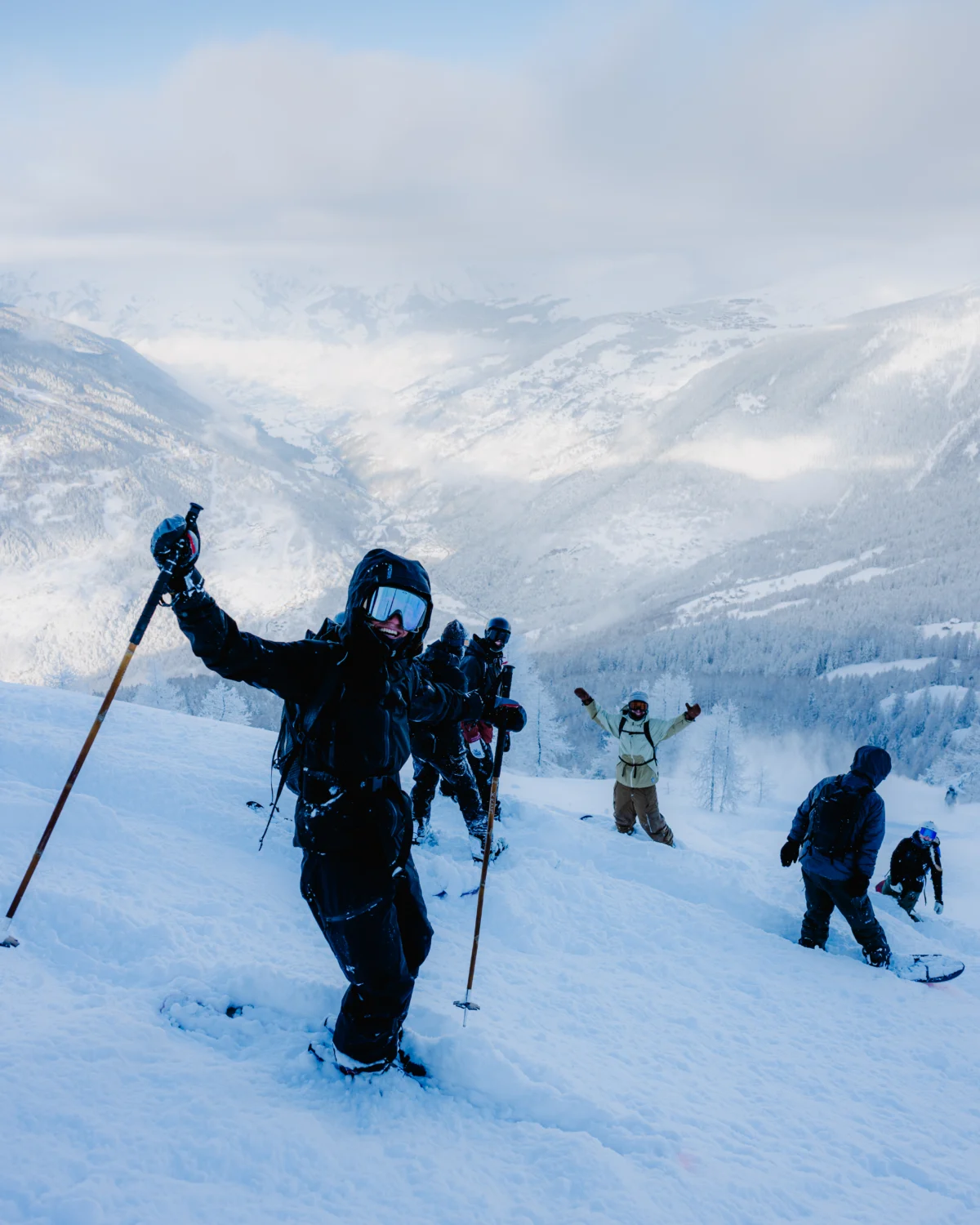 Groupe de skieurs et snowboardeurs progressant sur une pente enneigée.