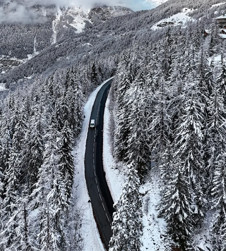 Une route traverse une forêt enneigée près de Sainte-Foy-Tarentaise.