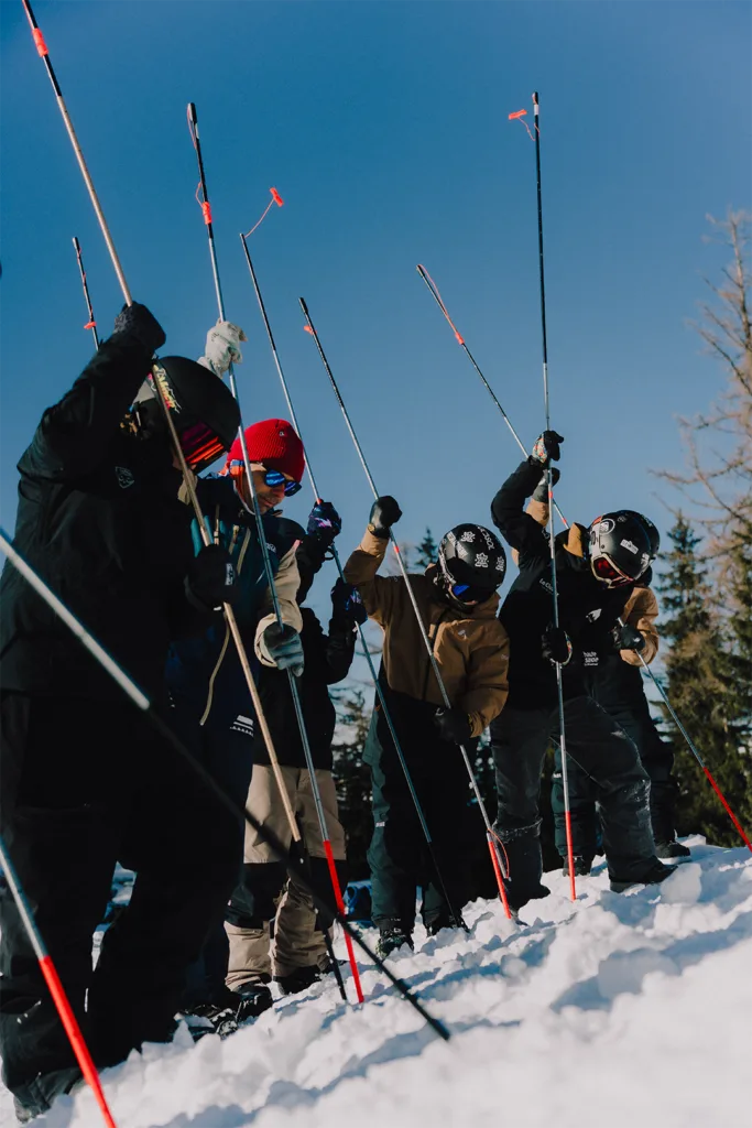 Des participants lèvent leurs sondes lors d’un atelier de recherche en avalanche.