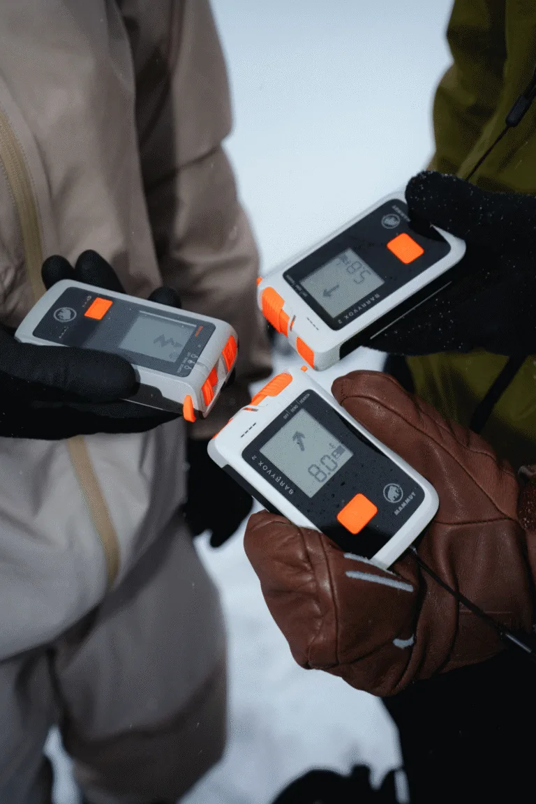 Gros plan sur plusieurs détecteurs de victimes d’avalanche tenus par des participants.