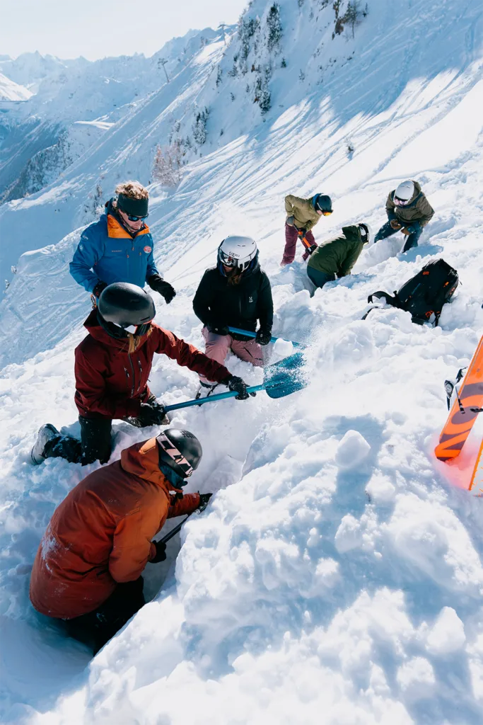 Des participants creusent en équipe dans une tranchée de neige.